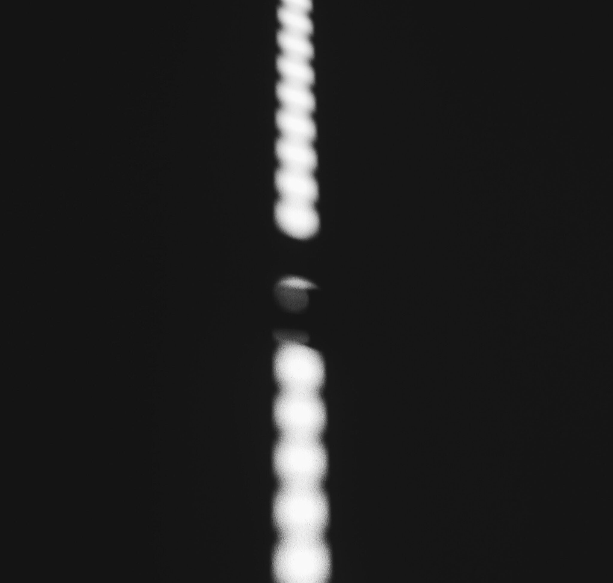 A row of white dots aligned behind a single black dot, representing consistent signals that build trust over time.