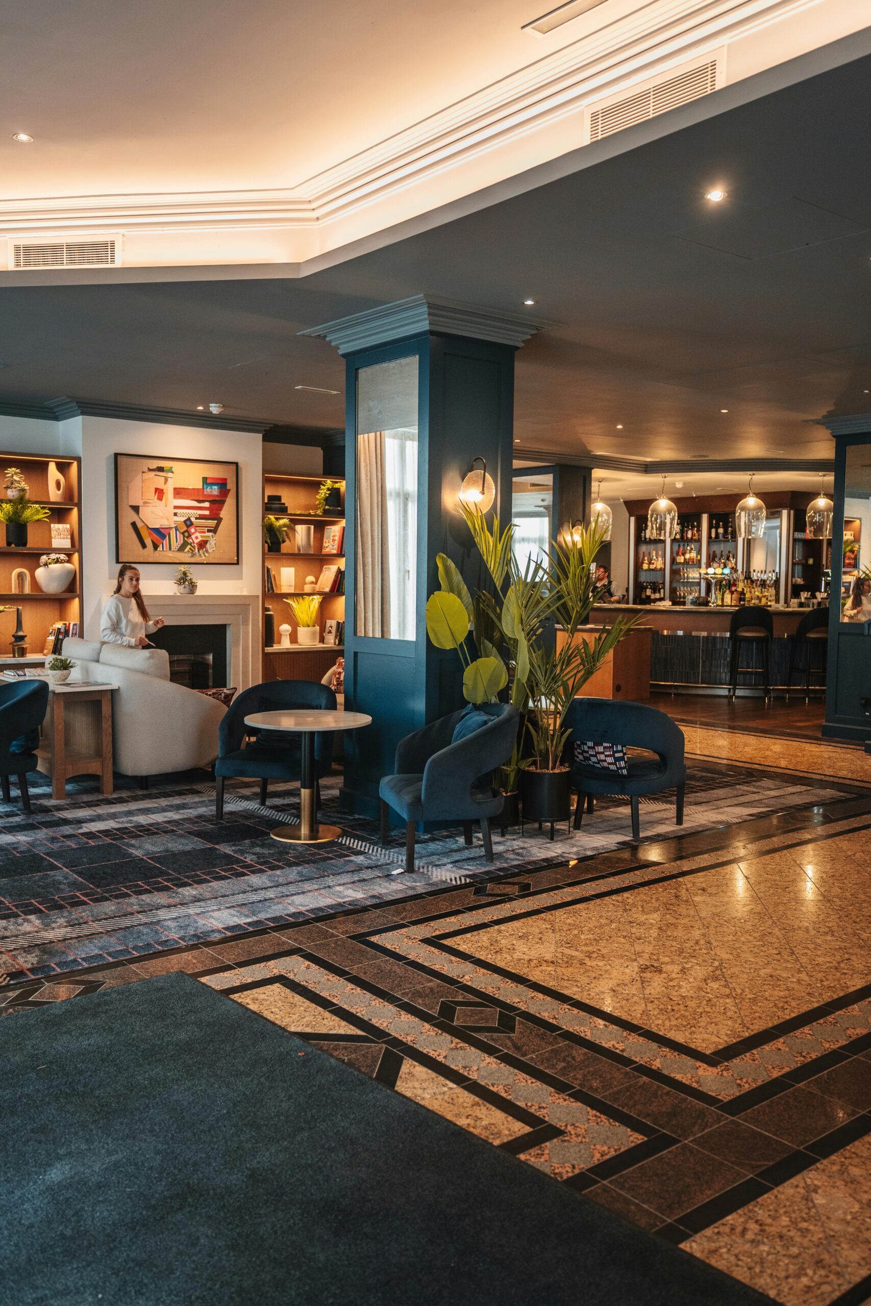 Woman relaxing in boutique hotel lobby representing hospitality reflection and guest perception in luxury hotel environment
