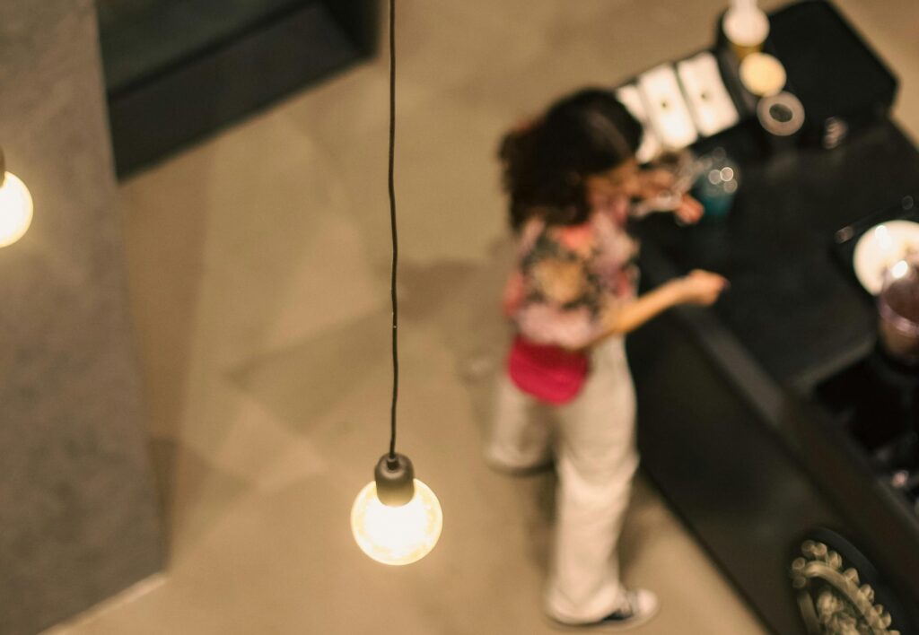 A woman standing in a hotel lobby waiting at reception, representing the guest experience at arrival.
