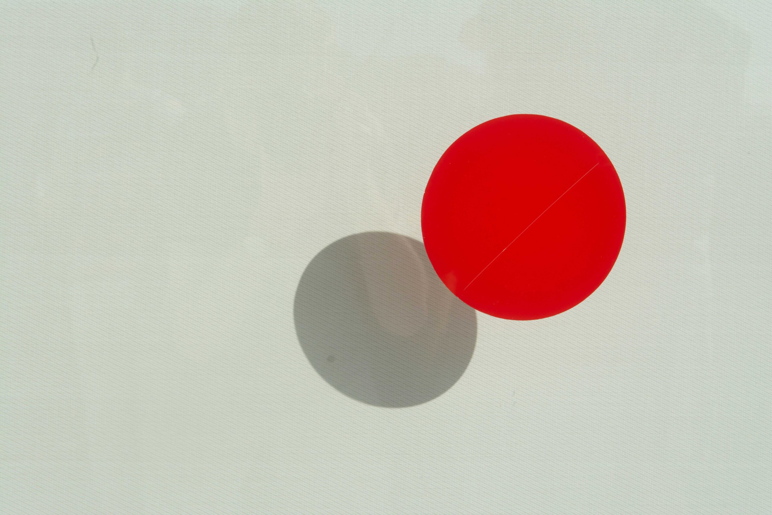 Two circles touching, with one appearing as the shadow of the other.