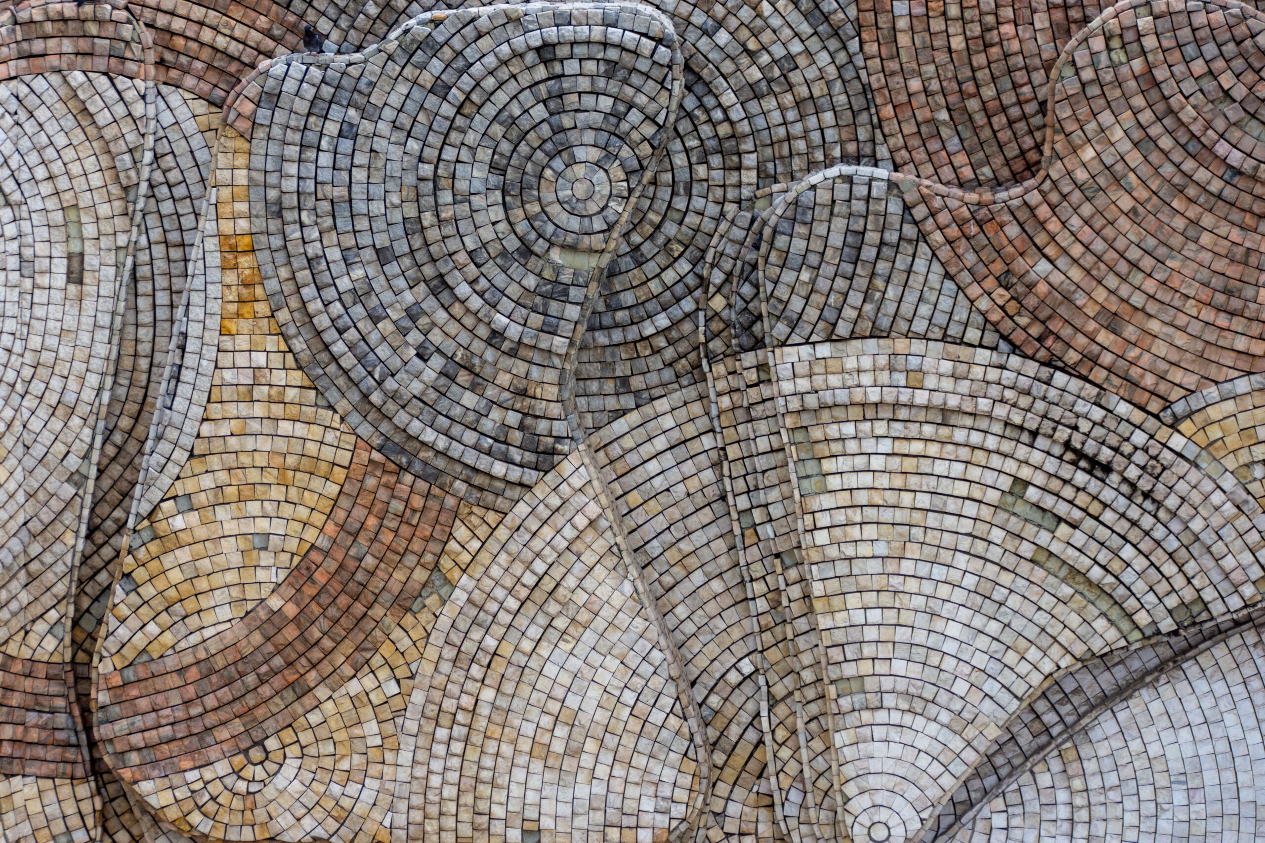 Abstract mosaic of circular stone patterns arranged at different heights and textures.